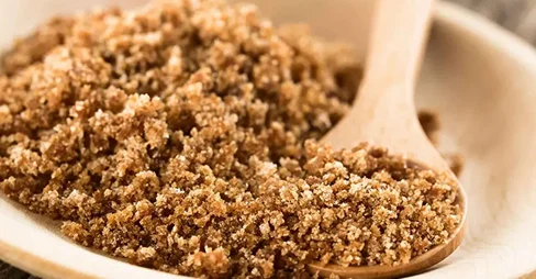 Bulk brown sugar and specialty sugars on a wooden plate